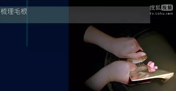 一手抓住毫尖部分，一手用骨梳，梳理毫根，把裏麵的斷毛、碎毛都梳出來。