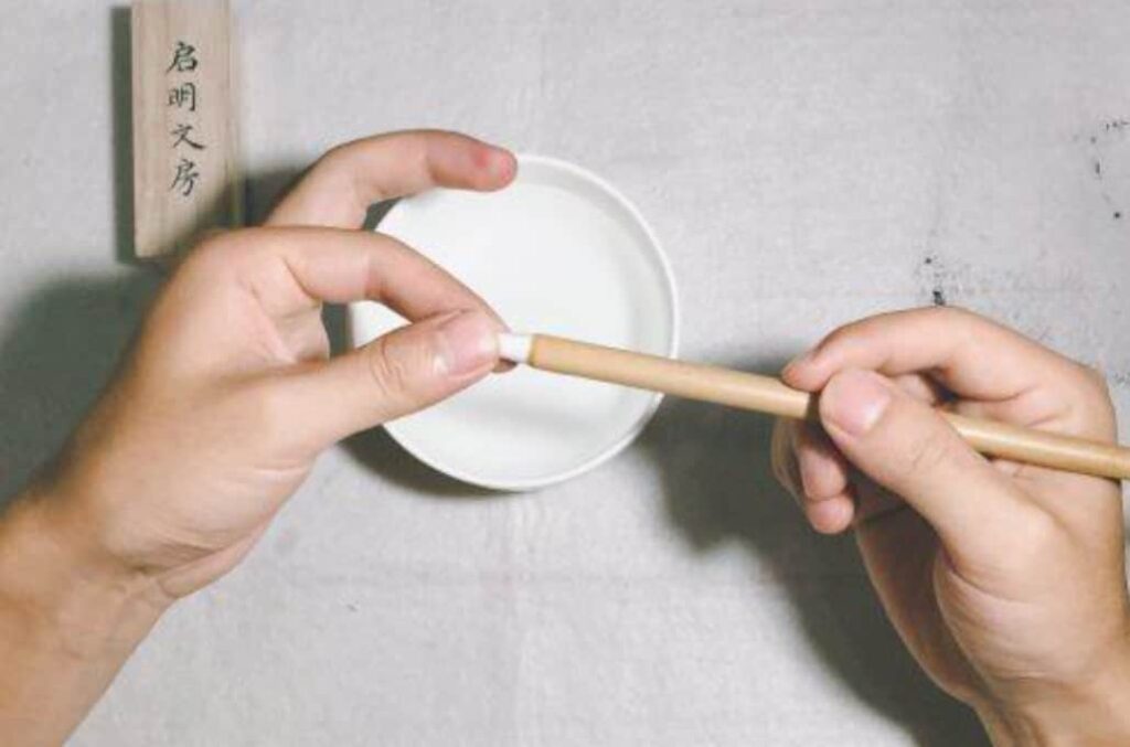 把毛筆從水中拿出來，輕微撚開，同時這個過程也可以把筆毛表麵的膠質擠掉。