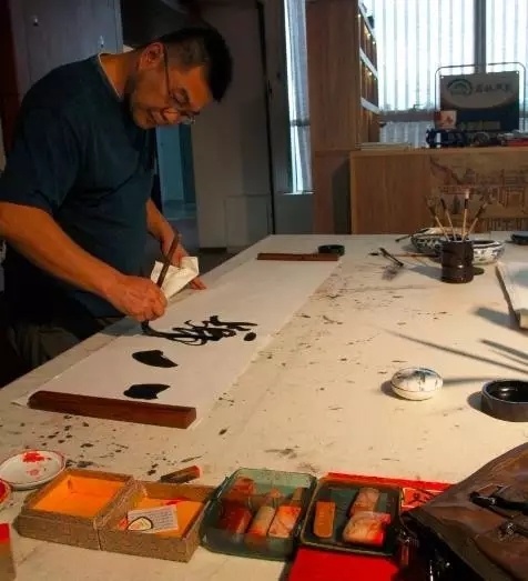 左手就拿著準備用來吸墨的宣紙