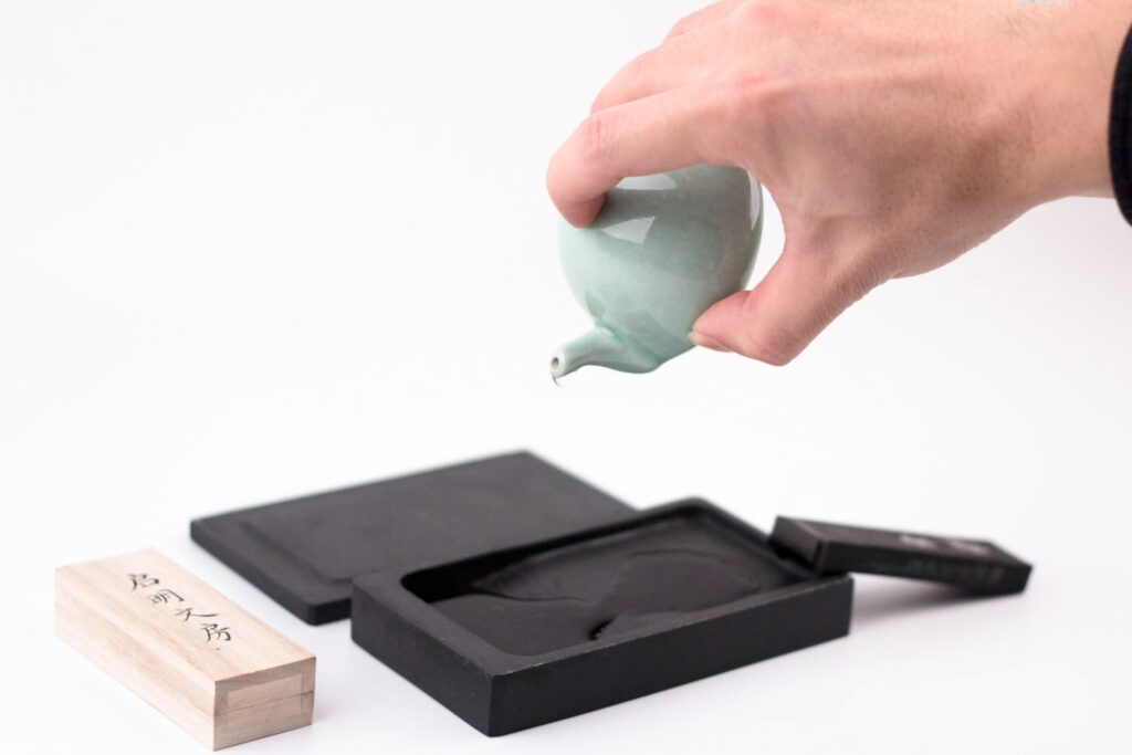 先用硯滴往硯台裏注入少量水。