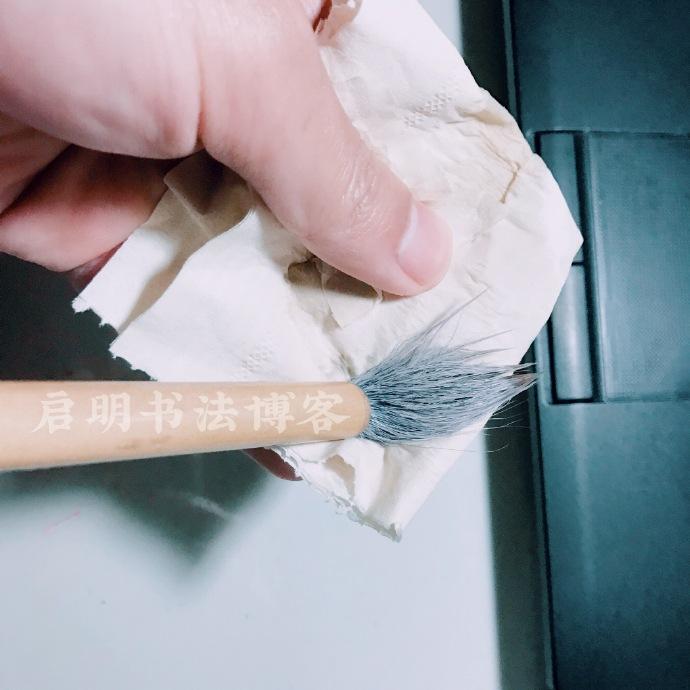 繼續旋轉著毛筆，讓毛筆的各個麵充分接觸紙巾。