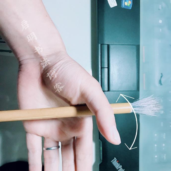 拿著毛筆在另一隻手的虎口穴來回敲打幾次